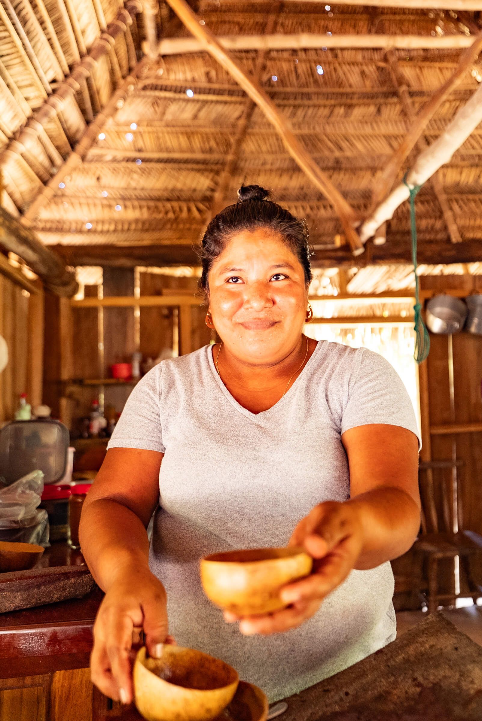 Kakaobäuerin in Guatemala reicht eine Tasse zeremoniellen Kakao